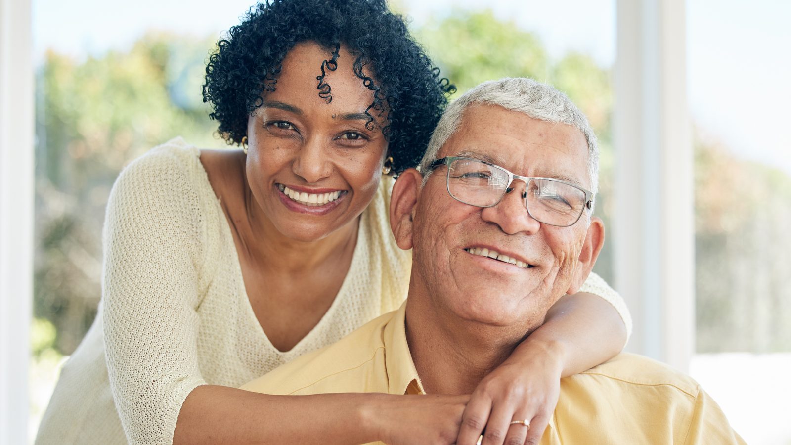 A smiling senior resident embraced by a loved one